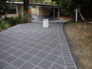 a grey tile patio with a white trash can