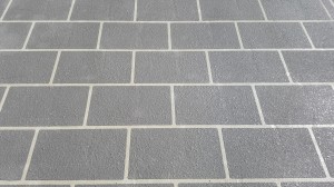 a grey brick floor with white lines